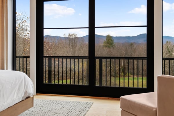 Stowe Woods bedroom with glass doors opening to a balcony and mountain views